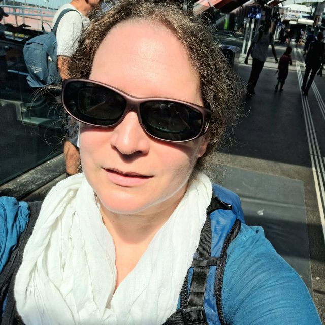 Susanne mit Sonnen-über-Brille. Selfie am Bahnhof Bern bei der Welle 7.