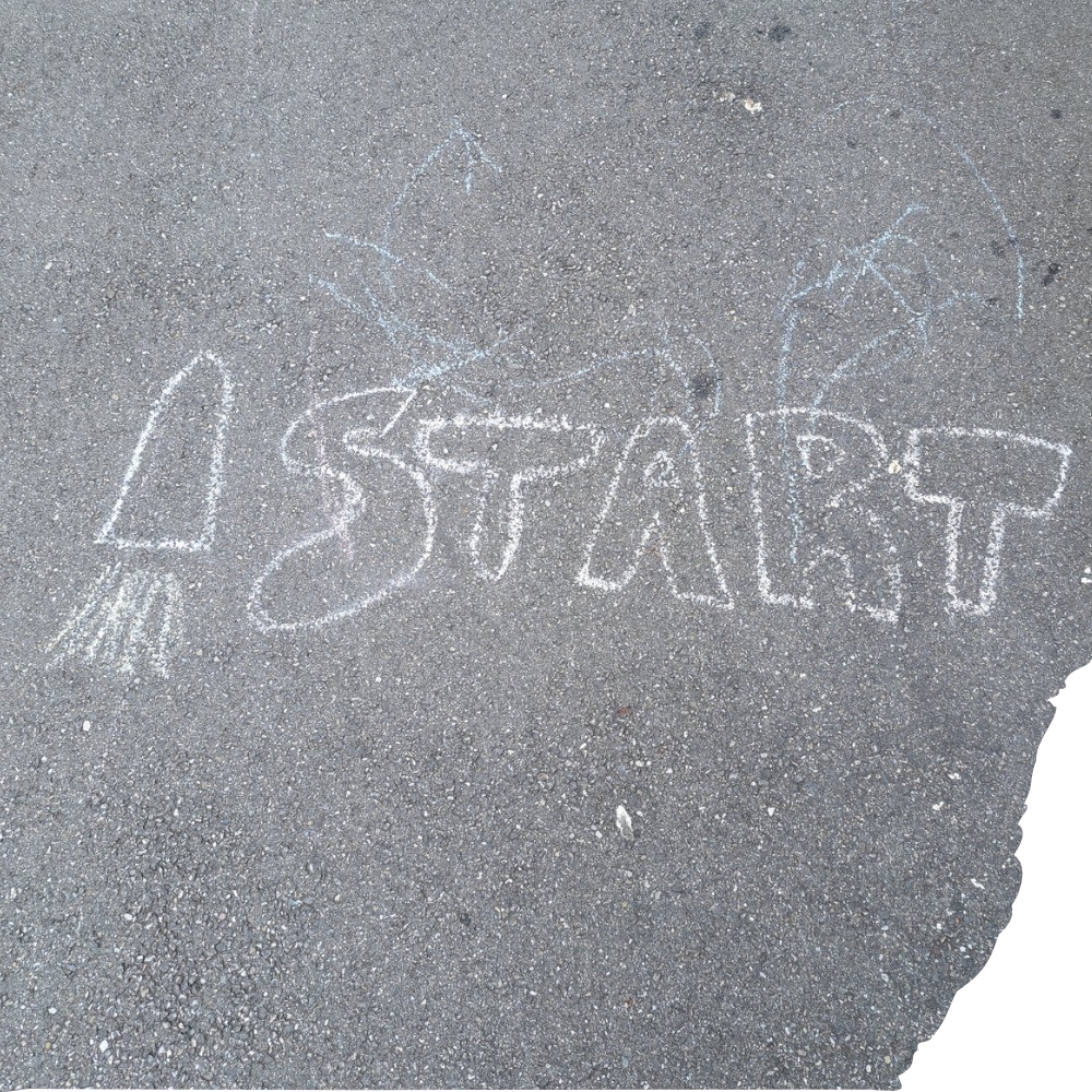 Das Wort START mit Kreide auf die Strasse gemalt, dazu eine Rakete mit viel Schub