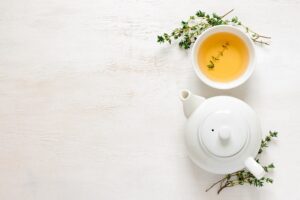 Teekrug, Teetasse, Kräuter, alles in weiss auf beruhigend leerem, hellem Tisch von oben geknipst. Bild von dungthuyvunguyen auf Pixabay