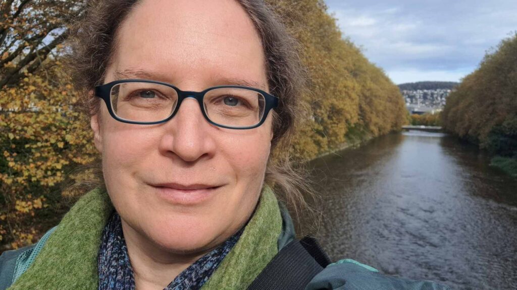 Porträt von Susanne, Sihl mit herbstlicher Platanenallee im Hintergrund