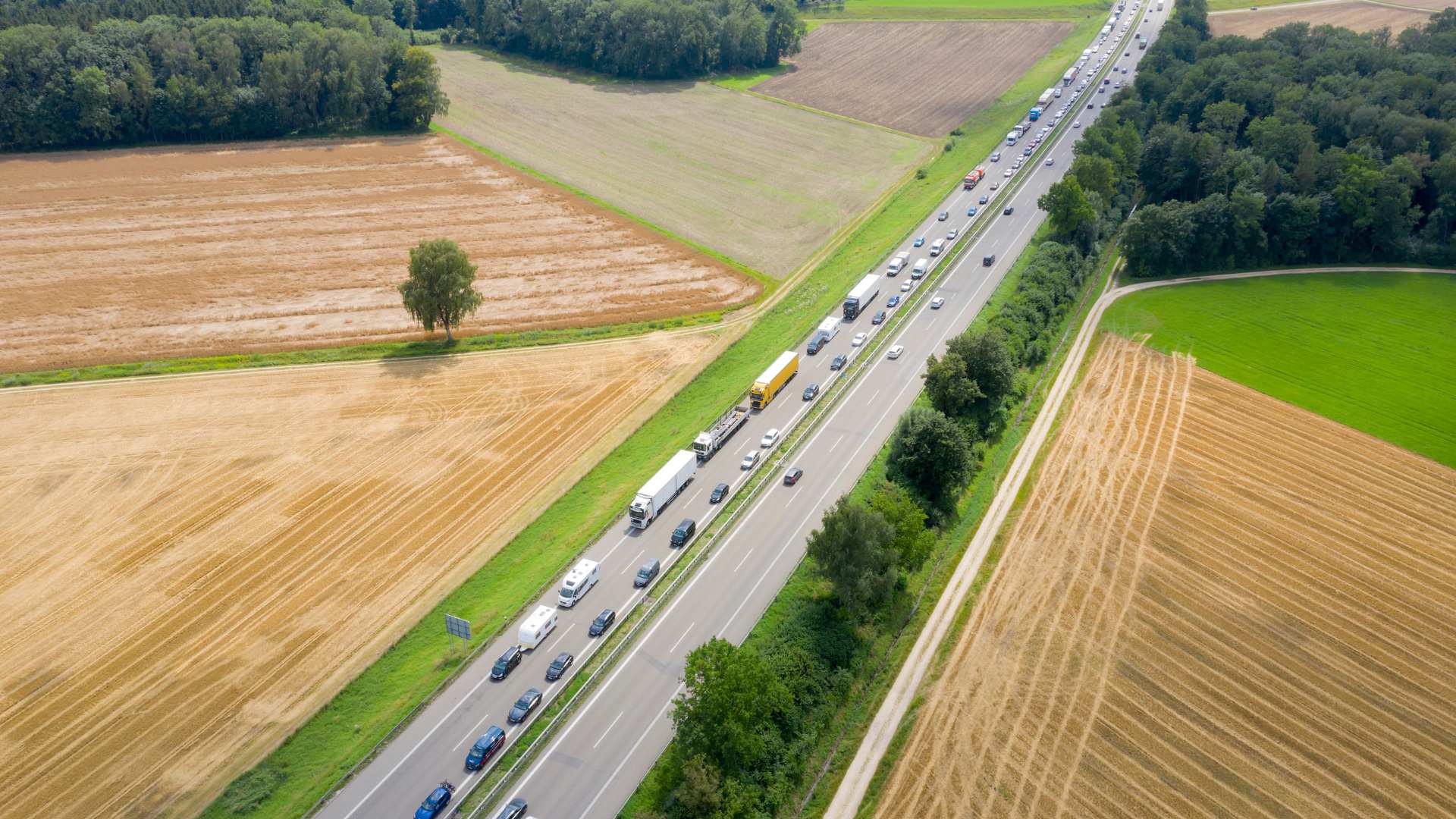 Luftaufnahme Autostrasse durch Kornfelder. Eine Richtung gestaut, andere freie Fahrt