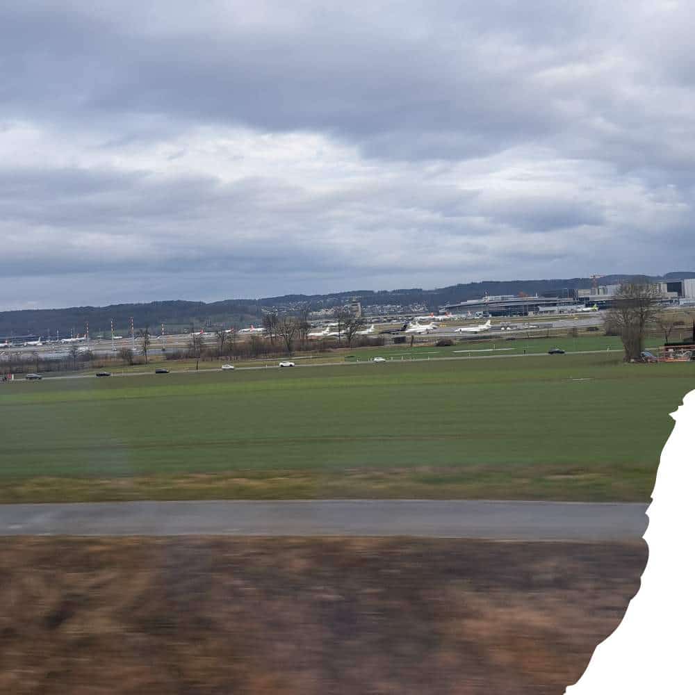 Blick aus der S-Bahn auf den Flughafen Kloten bei bedecktem Himmel