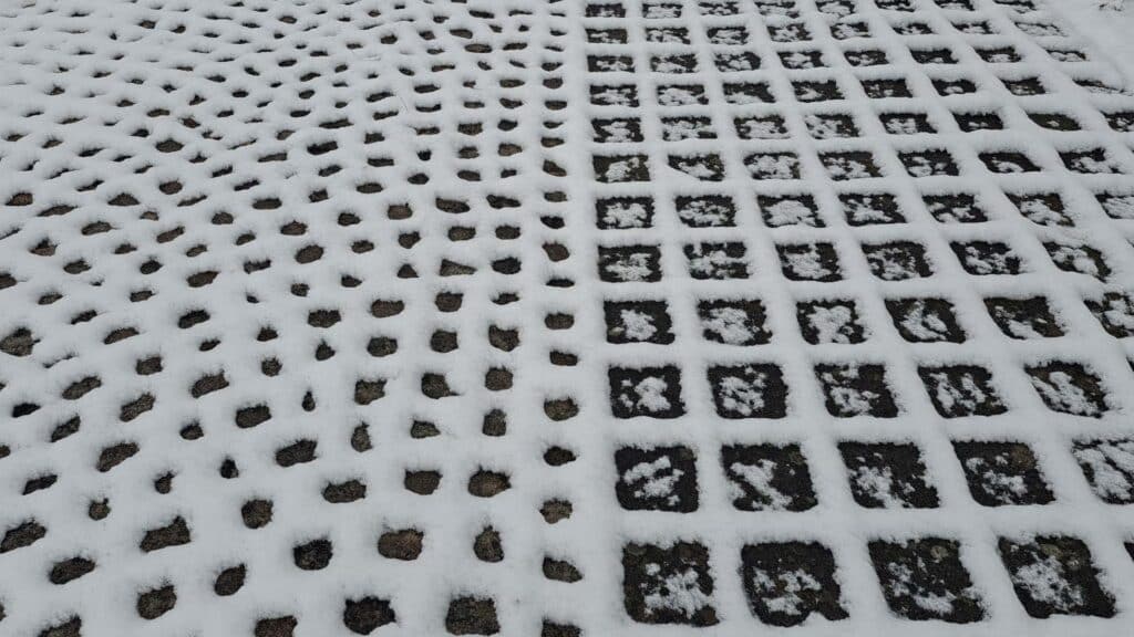 Muster auf verschneiten Bodenplatten mit grossen und kleinen Quadraten