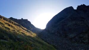 Sonne kommt hinter Bergrücken hervor